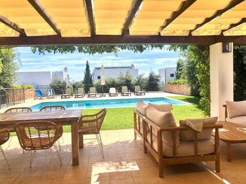 サン・リュイスにあるRoures 13 Villa con piscina privada y ACのテーブルと椅子とプールのあるパティオ