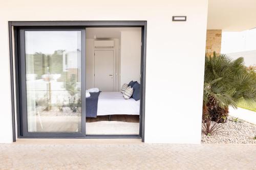 a sliding glass door with a bedroom outside at Paraiso da Foz Residence - BY SCH in Foz do Arelho