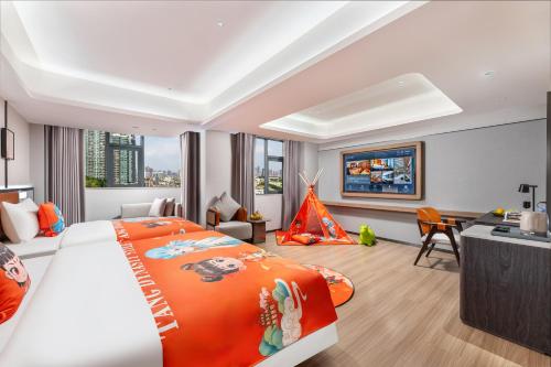 広州市にあるDingshe Hotel Guangzhou Shamian Island Yongqingfang Branchの大きなベッドと机があるホテルの部屋