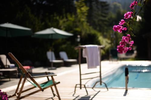 a couple of chairs sitting next to a swimming pool at House of Hütter - Wachtelhof & SPA in Maria Alm am Steinernen Meer