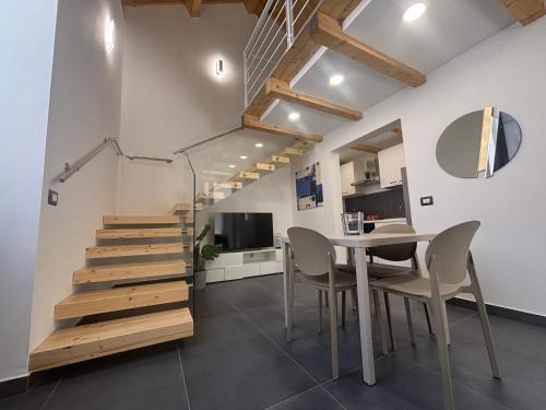 a kitchen and dining room with stairs and a table and chairs at Cortiletto Pavone A in Catania