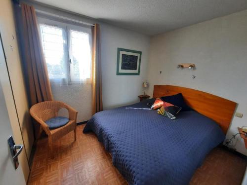 une chambre avec un lit, une chaise et une fenêtre dans l'établissement Maison à Marseillan plage, à Marseillan