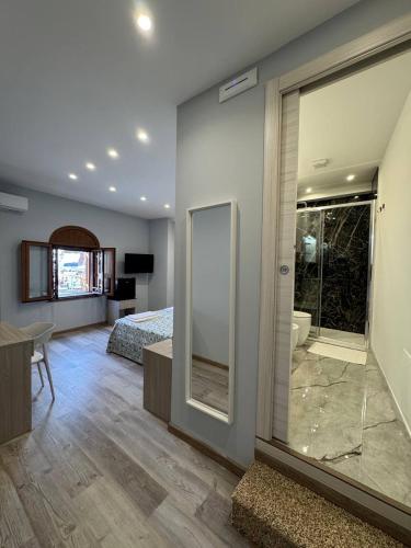 a bedroom with a bed and a bathroom with a mirror at Casa Calipso in Catania