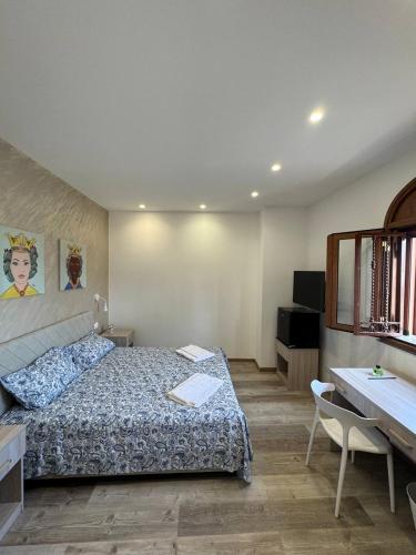 a bedroom with a bed and a table and a desk at Casa Calipso in Catania