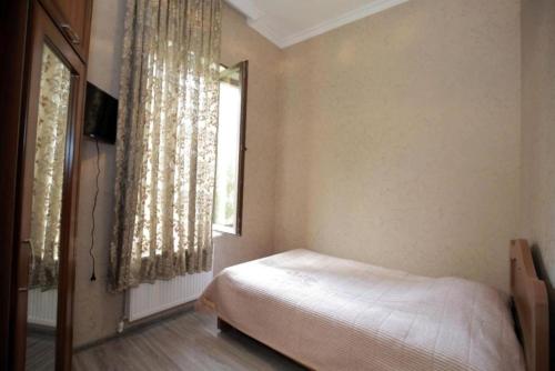 a bedroom with a bed and a window at Medea Guest House in Kutaisi
