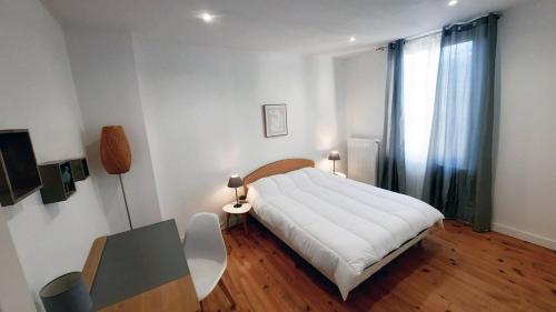 une chambre avec un lit, une table et une fenêtre dans l'établissement Maison paisible 24h du mans, à La Celle-sous-Gouzon