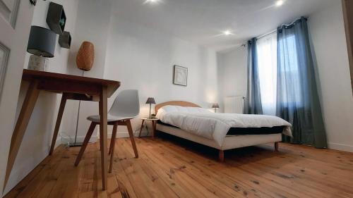 une chambre avec un lit, un bureau et une fenêtre dans l'établissement Maison paisible 24h du mans, à La Celle-sous-Gouzon