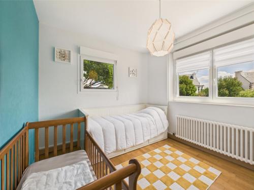 a baby crib in a room with a window at Piscine chauffée, plage à 700m, maison pour 6 in Pléneuf-Val-André