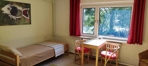 a bedroom with a bed and a table and a window at Rügen FeWo-Lohme auf Jasmund in Lohme