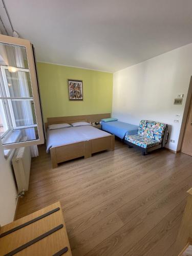 a room with two beds and a couch and a window at Hotel Bel Sit in Comano Terme