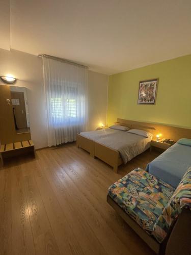 a hotel room with two beds and a television at Hotel Bel Sit in Comano Terme