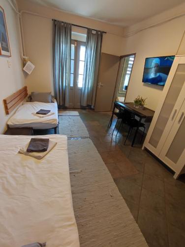 a room with two beds and a table in it at Deák Szobák in Nagykőrös