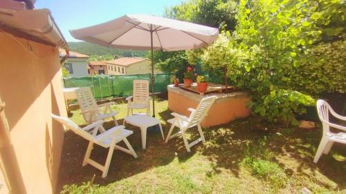 a patio with a table and chairs and an umbrella at Dimora toscana in Santa Maria del Giudice