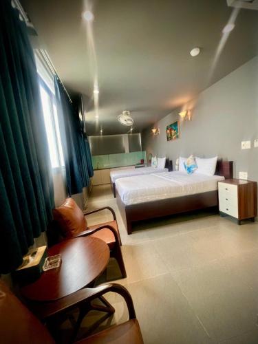 a bedroom with a bed and a chair and a table at ĐÔNG NHƯ HOTEL in Ho Chi Minh City
