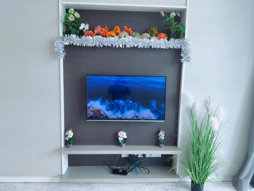 a television on a wall with flowers on it at KLCC Suites At Platinum By MiM in Kuala Lumpur