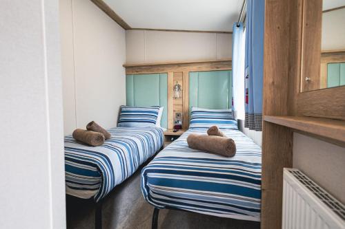 a row of blue and white striped beds in a room at The Jetty in Christchurch