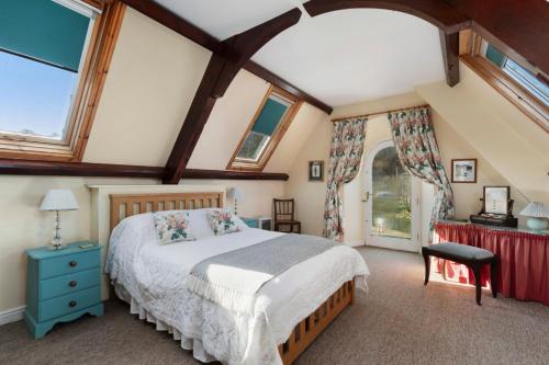 a bedroom with a large bed and windows at Llanfor in Fishguard