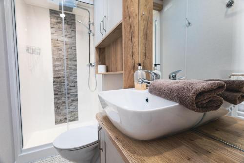 a bathroom with a white sink and a shower at The Jetty in Christchurch