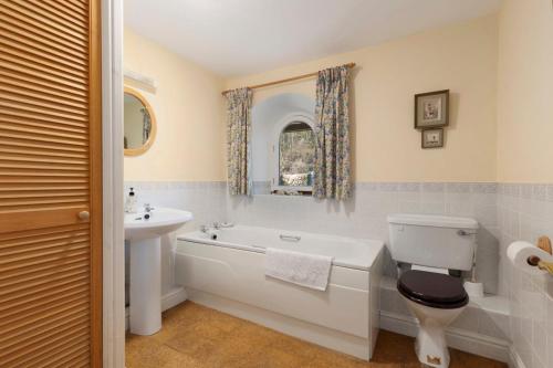 a bathroom with a tub and a toilet and a sink at Llanfor in Fishguard
