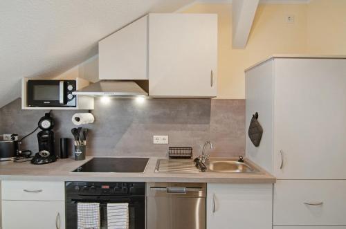 a kitchen with white cabinets and a sink at Ferienhaus Berger 2025 in Bad Karlshafen