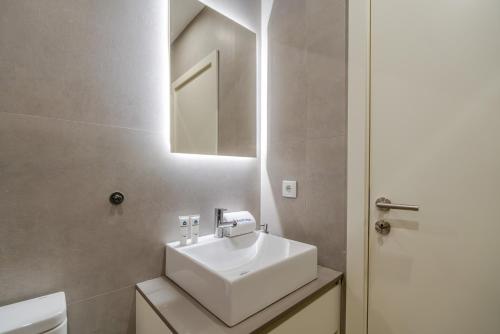 a bathroom with a white sink and a mirror at HostWise - Premium & Modern Building in Porto