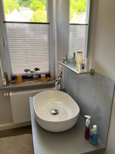 a bathroom with a white sink and two windows at Ferienhaus Berger 2025 in Bad Karlshafen