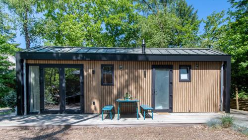 a tiny house with a table on a patio at Tinyhouse Grasmus in Nunspeet