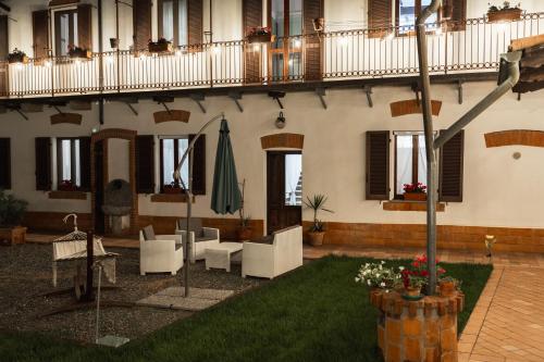 a building with a patio with chairs and an umbrella at Casa Pierre in Castelnuovo Bormida