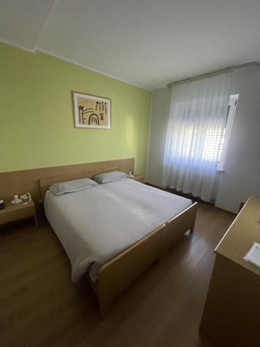 a large bed in a room with a window at Hotel Bel Sit in Comano Terme