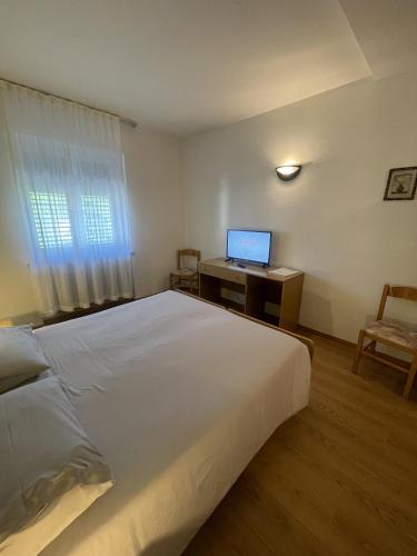 a bedroom with a bed and a desk with a computer at Hotel Bel Sit in Comano Terme