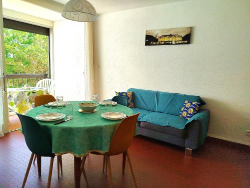 un salon avec une table et un canapé bleu dans l'établissement Proche du port beau T3 lumineux tout confort avec parking - 4RS121, à Saint-Cyprien