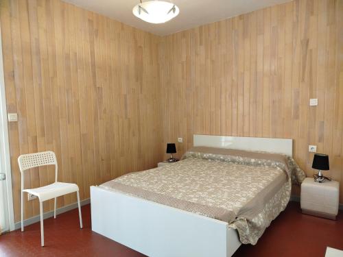 - une chambre avec un lit blanc et une chaise blanche dans l'établissement Proche du port beau T3 lumineux tout confort avec parking - 4RS121, à Saint-Cyprien