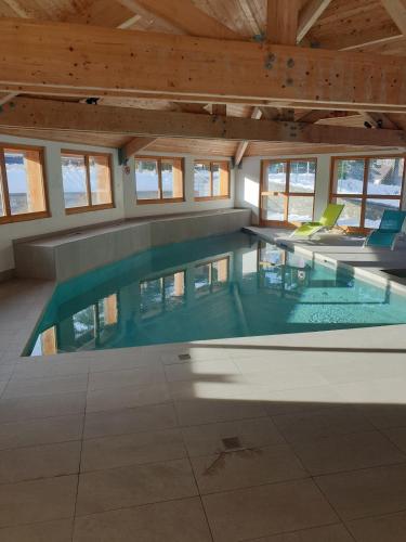 - une grande piscine dans un bâtiment doté de fenêtres dans l'établissement Appartement 3 étoiles pour 4 personnes avec piscine, à La Joue du Loup