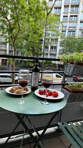 - une table avec deux verres de vin et de nourriture dans l'établissement Évasion confort, à Paris