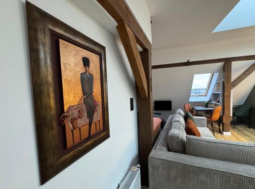 a living room with a couch and a painting on the wall at Apartament Fyrtel in Poznań
