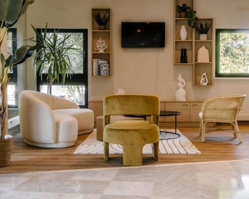 a living room with furniture and a tv at 7Hotel&Spa in Illkirch-Graffenstaden