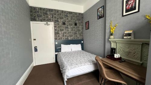 a bedroom with a bed and a desk and a table at Charlotte Guest House in London
