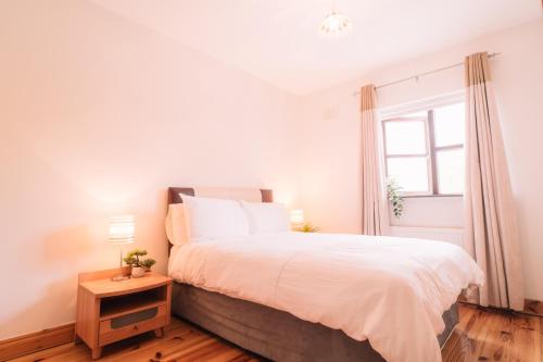 a bedroom with a large bed and a window at 3 bedroom Townhouse in the heart of the Burren in Ballyvaughan