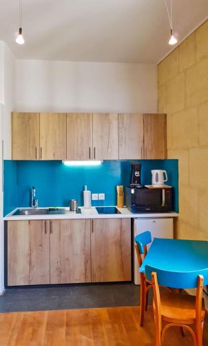 une cuisine avec des murs bleus et une table bleue dans l'établissement Studio avec vue sur l'Amphithéâtre-arènes, à Arles