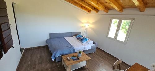 a bedroom with a bed and a table and a window at Near the Sea Hideaway Bay Oasis in Rogačić
