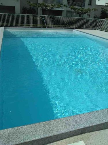 une grande piscine avec de l'eau bleue dans l'établissement Appartement rénové avec piscine, plage 2mns à pied, au Cap d'Agde