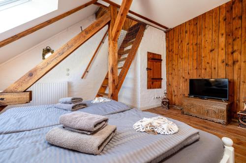 VaschvitzにあるFährhaus Wittowの木製の壁とテレビが備わる客室で、ベッド2台が付いています。