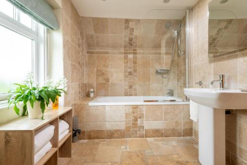 un baño con bañera y lavabo en Forge 2 bedrooms, en Beverley