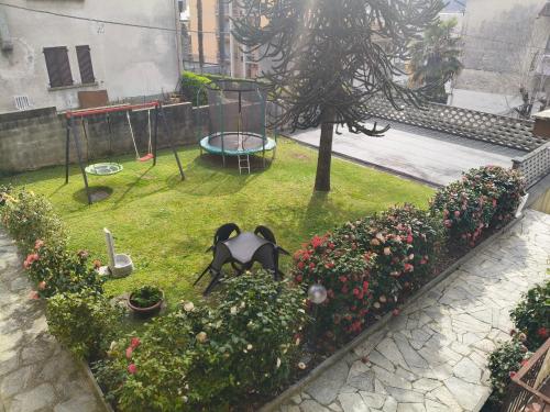 a garden with a statue and flowers and a swing at Residenza Gattoni in Omegna