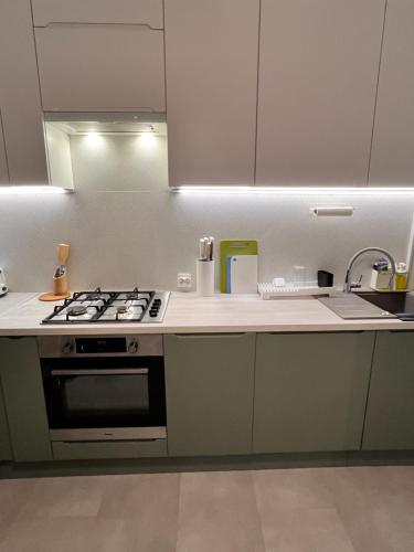 a kitchen with white cabinets and a stove top oven at Apartament Aleje in Dąbrowa Górnicza