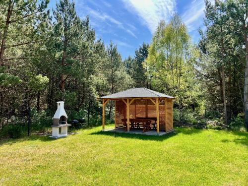 a wooden cabin with a gazebo in a field at Ostrowo Plaza in Ostrowo