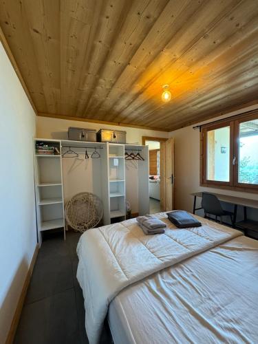 une chambre avec un grand lit avec un plafond en bois dans l'établissement Cosy Mountain _ free park, à Montgenèvre