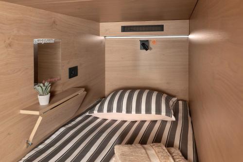 a small room with a bed and a mirror at U-NIGHT Hostel Budva in Budva