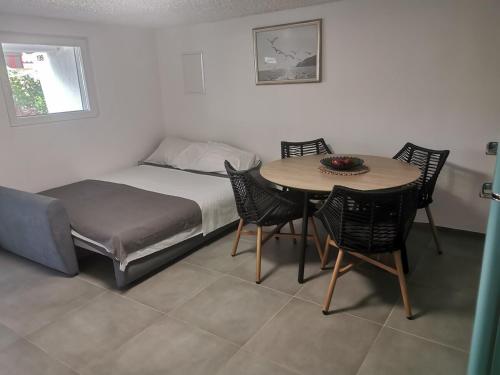 a bedroom with a bed and a table and chairs at Casa Maslina - 1 in Ražanac