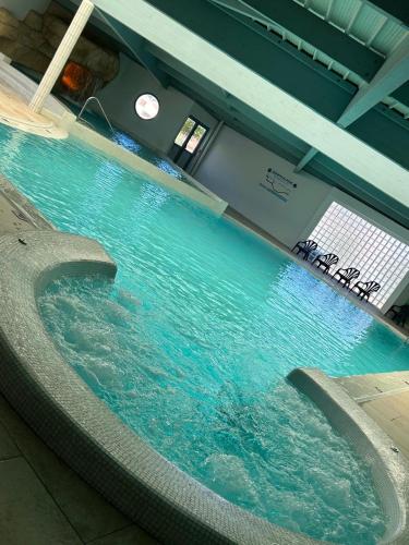 une grande piscine d'eau avec une horloge sur le mur dans l'établissement Sol à gogo 3 Chambres à 50 m de la plage, à Saint-Hilaire-de-Riez